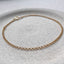 product shot showing a dainty gold rolo chain lying in a stoneware dish