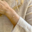 Three strand pearl bracelet with freshwater pearls and delicate beads worn on a wrist, perfect for everyday wear.