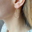 Dainty circle earrings shown on a model