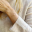 Delicate three strand pearl bracelet in 14k gold filled on a woman's wrist, perfect for minimalist style.