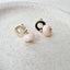 gold filled circle stud earrings adorned with baby pink opal roundel drops are displayed on a stoneware jewelry dish
