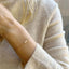 Three strand pearl bracelet with freshwater pearls and delicate beads worn on a wrist, showcasing minimalist style.