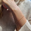 up close model shot of arm wearing a dainty gold rolo chain bracelet