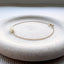 Gold opal bracelet on a white stone surface