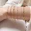 model shot of arm wearing a dainty gold rolo chain bracelet in a bracelet stack with a gold Figaro chain bracelet, gold rolo chain bracelet, gold satellite chain bracelet, gold curb chain bracelet and gold dapped chain bracelet