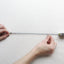 Shows someone measuring a string with a ruler for the perfect necklace length