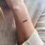 A model is wearing a dainty chain bracelet with beaded sapphires