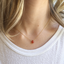 Dainty carnelian teardrop necklace worn at the collarbone