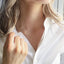 Model shown wearing a very dainty gold open heart charm necklace. The gold heart texture is smooth and very thin.