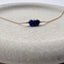 Gold bracelet with blue sapphire beads on a stone surface