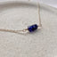 Necklace with blue sapphire beads on a beige surface