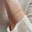 up close model shot of arm wearing a dainty gold rolo chain bracelet 