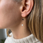 Black onyx and pearl threader earring worn on the ear - Lolabean