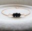 Dainty black onyx bracelet with three faceted stones on a gold filled chain