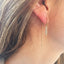 Aquamarine beaded threader earrings worn in ear with delicate gold chain
