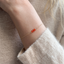Dainty carnelian bracelet worn with a cream sweater