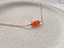 Carnelian beaded necklace in 14k gold-filled on a stone dish