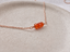 Carnelian beaded necklace in 14k rose gold-filled on a stone dish