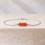 Dainty carnelian bracelet in sterling silver on travertine