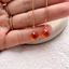 Pair of faceted carnelian threader earrings held in hand