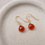 Carnelian heart drop earrings in 14k gold-filled on a speckled ceramic dish
