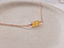 Three-bead citrine necklace in 14k rose gold-filled on a cream dish