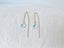 Aquamarine threader earrings laid flat on neutral linen background
