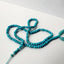Turquoise beads with tassel on a white background