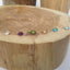 Dainty gold filled birthstone necklaces with assorted gemstones on wood display