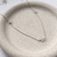 Sterling silver cubic zirconia station necklace on a speckled ceramic dish