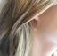 Close-up of a delicate citrine hoop earring showing the faceted gemstone