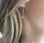 Detail of a dainty gold hoop earring with a citrine gemstone