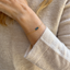 Dainty 14k gold-filled London blue topaz bracelet worn on wrist beside a soft ivory sweater cuff