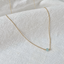 Gold-filled faceted aquamarine bead necklace on textured white linen