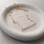 Rose quartz beaded bar necklace in 14k gold filled with faceted pink rose quartz rondelles on a fine cable chain, in a stone dish