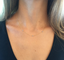 Three-stone cubic zirconia necklace on a gold-filled chain worn with a black top
