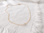 Gold-filled dainty freshwater pearl necklace on white linen