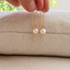 Dainty pearl threader earrings in 14k gold filled with a single freshwater pearl on a fine cable chain, in a speckled ceramic dish