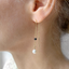 Close-up of black onyx and pearl threader earring on the ear - Lolabean