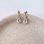 Gold-filled cubic zirconia briolette drop stud earrings on the rim of a stone dish