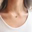 Dainty labradorite teardrop necklace worn at the collarbone