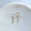 Gold-filled mint green prehnite drop earrings on a white marble dish