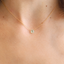 Close-up of a small prehnite heart necklace worn at the collarbone