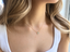 Model wearing a gold-filled prehnite teardrop necklace at the collarbone with a white ribbed tank