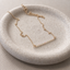 Gold filled opal beaded bar necklace on a speckled ceramic dish