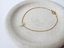 Opal teardrop bracelet with spring ring clasp on a speckled ceramic dish
