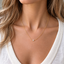 Single freshwater pearl necklace on a gold-filled chain worn with a white V-neck