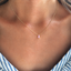 Pink opal teardrop necklace in gold filled worn at the collarbone with a striped blouse