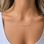 Model wearing a rose quartz beaded bar necklace in sterling silver with faceted pink rose quartz beads