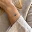 Model wearing a delicate 14k gold-filled London blue topaz three-bead bracelet with an ivory knit sweater